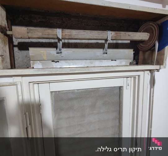 מנגנון תריס גלילה עם ציר עץ ורצועות מתכת